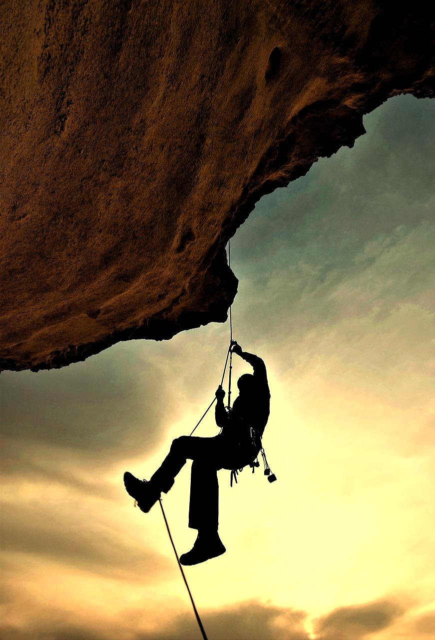 Person rock climbing on a sunny cliff face